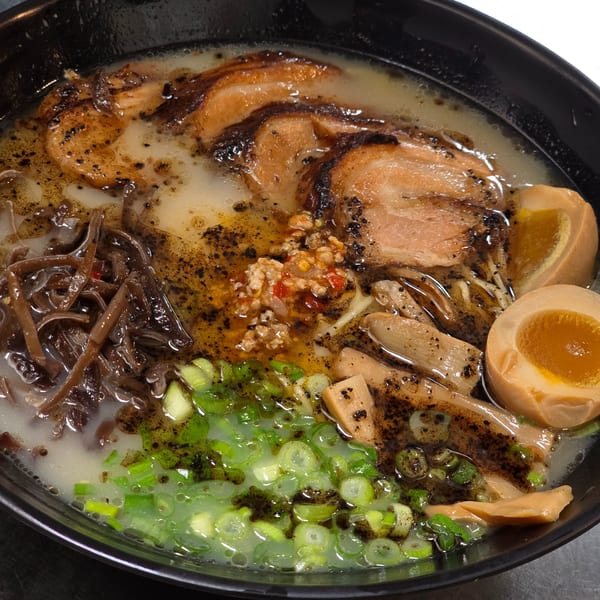 Close-up of Momoyama Ramen with pork, egg, mushrooms, green onions, and chili paste.