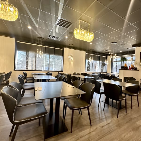 Modern dining room at Momoyama Ramen & Hawaiian BBQ with dark tables, chairs, and chandeliers.