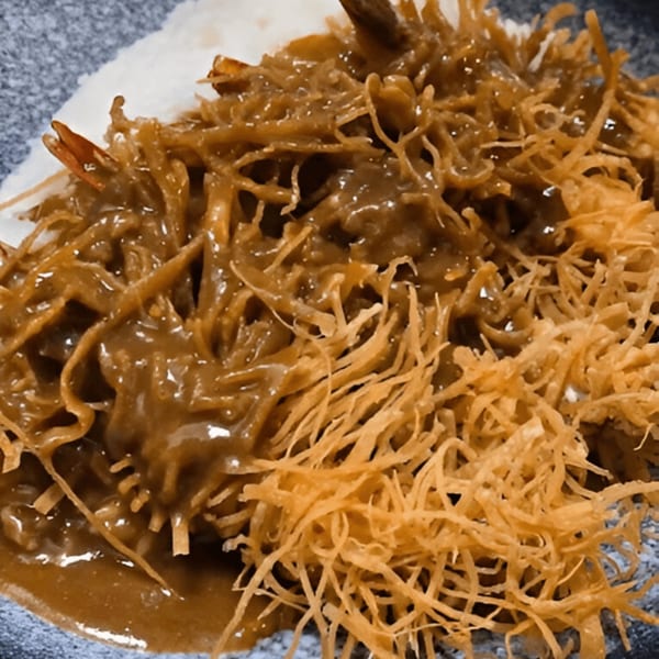 Close-up of Momoyama Ramen's Hawaiian BBQ dish with shredded meat, sauce, and crispy toppings.
